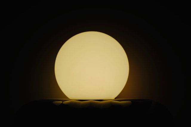 Zapálená lampa v tvare gule v tme.jpg